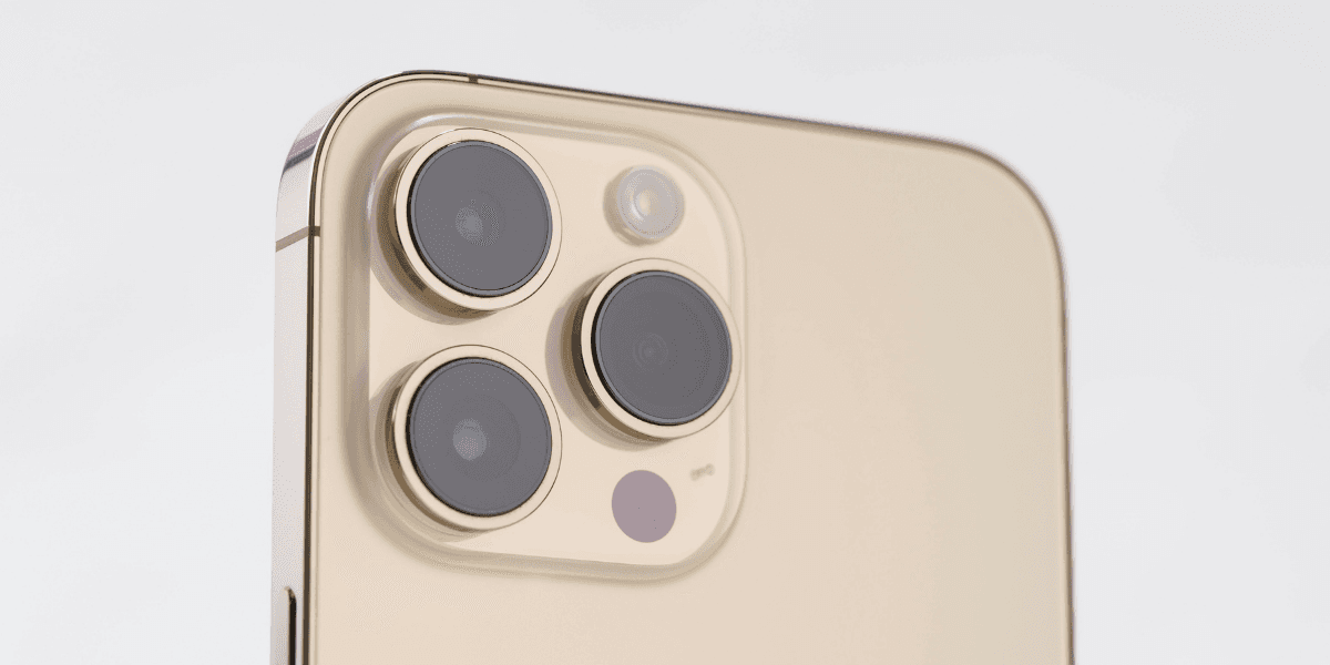 Close-up of a smartphone's rear camera module featuring three lenses and a flash