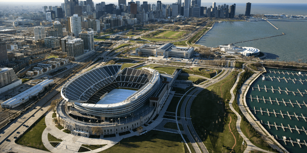 Aerial view of a stadium near a city skyline and waterfront park area