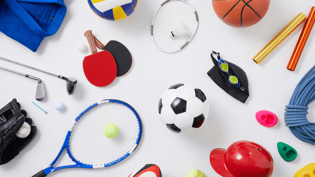 Assorted sports equipment including soccer ball, tennis racket, basketball, swimming goggles, and baseball glove on a white background.