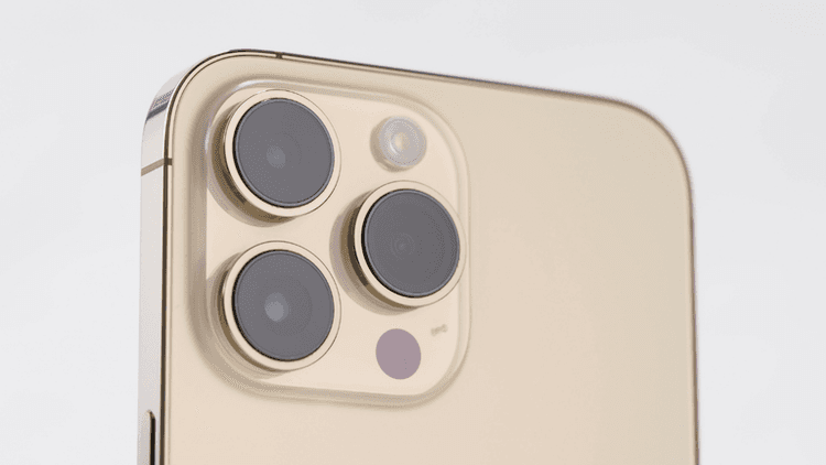 Close-up of a smartphone's rear camera module featuring three lenses and a flash