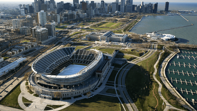 Aerial view of a stadium near a city skyline and waterfront park area
