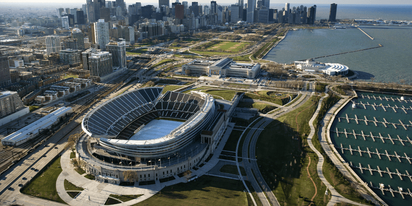 Aerial view of a stadium near a city skyline and waterfront park area