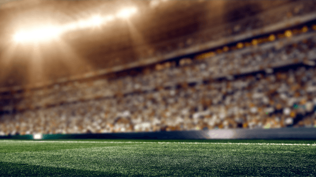 Blurry view of a stadium with bright lights and blurred crowd in the background