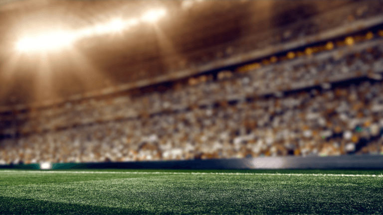 Blurry view of a stadium with bright lights and blurred crowd in the background