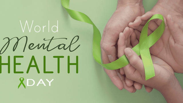 Hands holding a green ribbon, symbolizing World Mental Health Day awareness and support